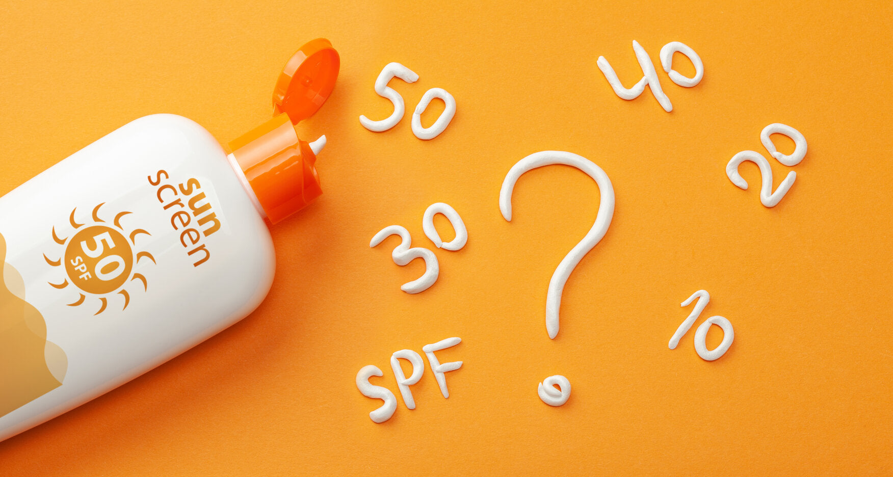 Image of sunscreen with SPF 50 on an orange background, surrounded by SPF numbers written in cream, illustrating the importance of understanding sun protection ratings.